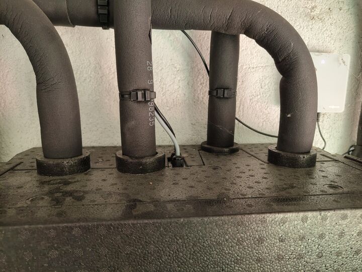 Four upper pipe runs at the secondary pump / mixer group. Top of insulated group · straight on.