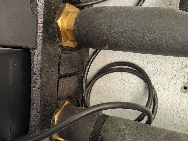 Two brass union connections behind the insulated group. Rear/right side · tighter close-up.