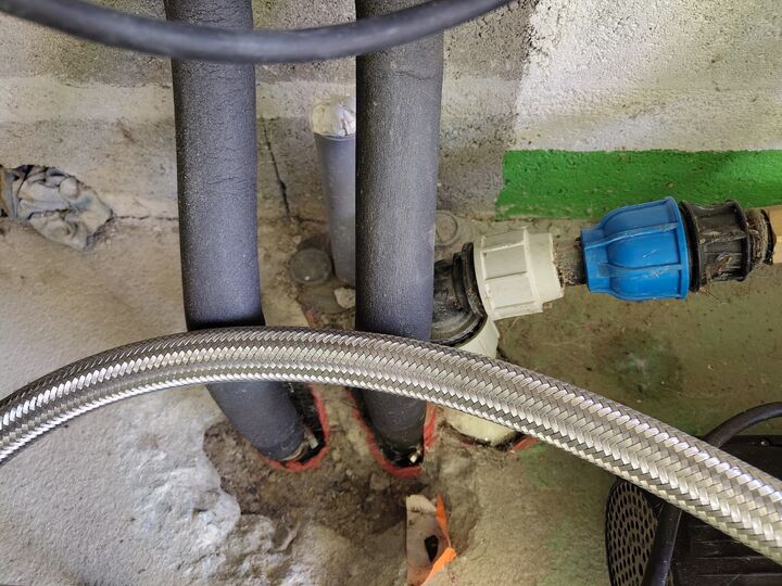 Two insulated pipes entering the plant-room floor. Floor entry · close context.